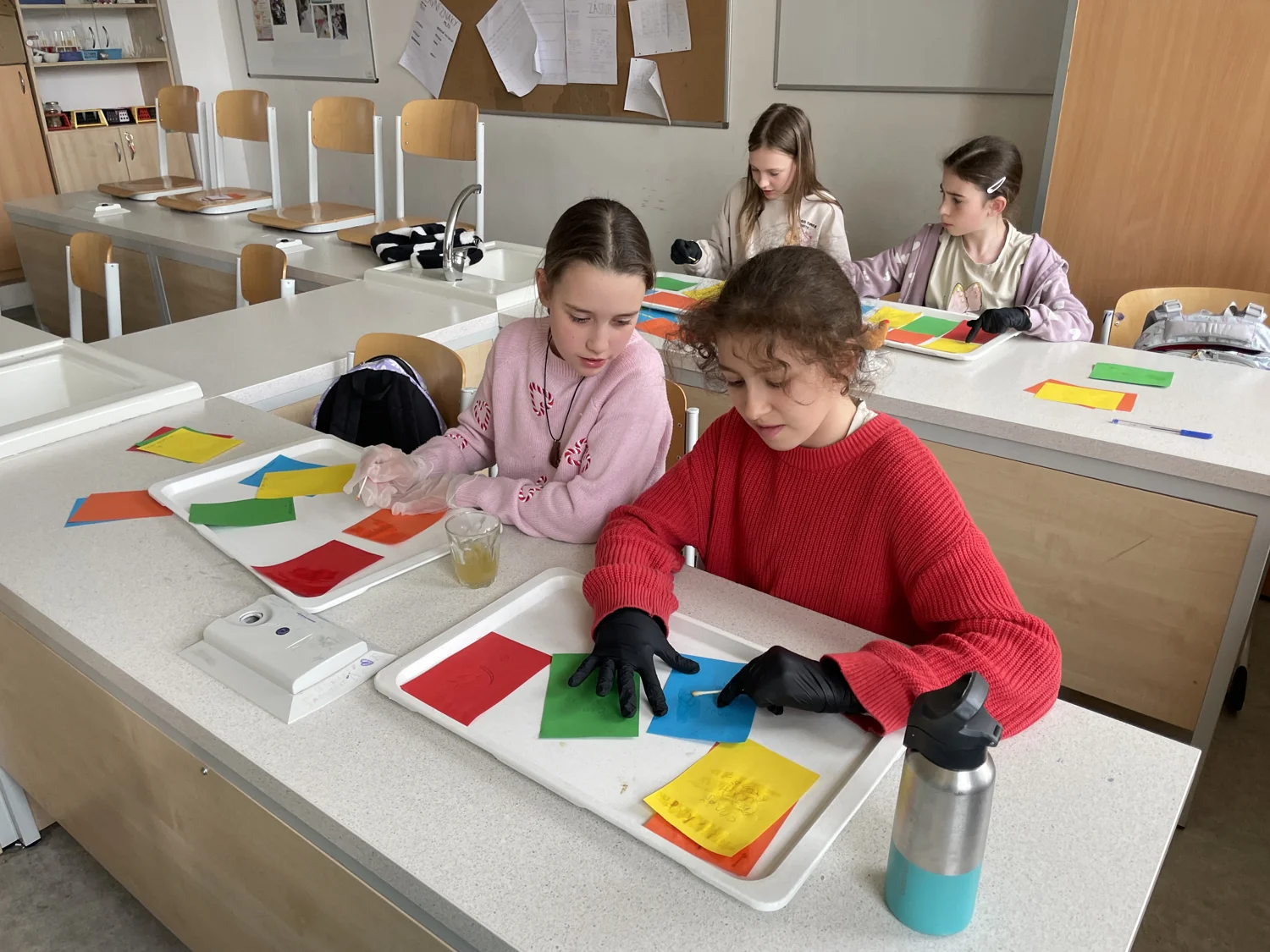 Děti u společného stolu tvoří a pracují s barevnými materiály